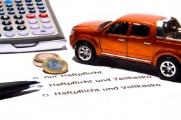 Taschenrechner, Münzen und ein Modellauto